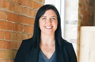 Career Marketing Techniques - professional middle aged female standing in front of a brick wall.