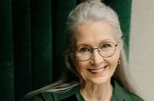 Career Marketing Techniques - Senior smiling lady with glasses and green shirt